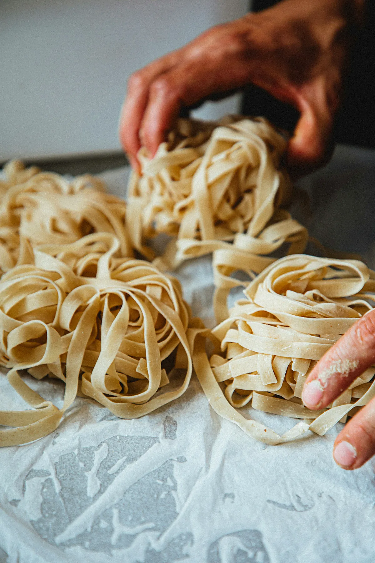Mani che raccolgono nidi di tagliatelle